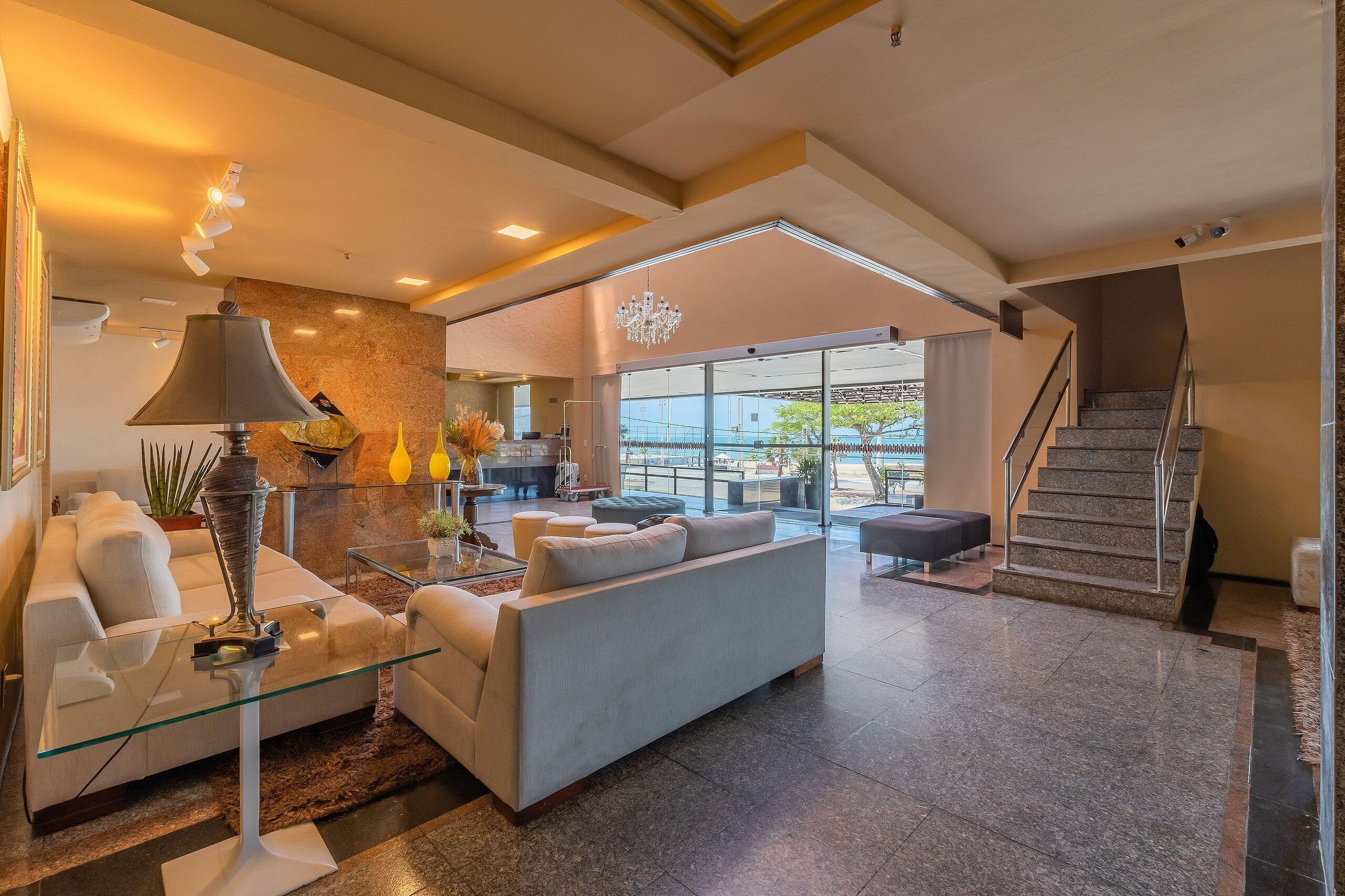 A modern living room with a sofa, glass coffee table, and a lamp.