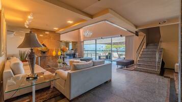A modern living room with a sofa, glass coffee table, and a lamp.