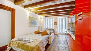 Un dormitorio con cama, escritorio y kitchenette.
