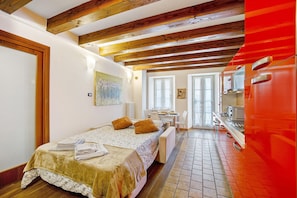 Une chambre comprenant un lit, un bureau et un coin cuisine.