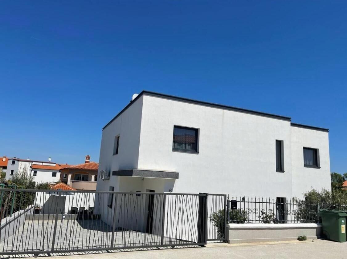 A modern two-story building with a flat roof and a white exterior.