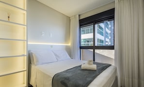 A hotel room with a bed, a window with curtains, a wall-mounted shelf with a bottle, and a Star of David decoration. - Apt w/ Bbq, 80m From the Beach Ret0801 (Picarras)