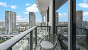Un balcón con vistas a un paisaje urbano, con rascacielos y un cielo despejado.