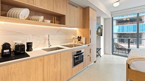 Una cocina moderna con armarios de madera, horno empotrado, cafetera y un amplio ventanal con vistas al exterior.