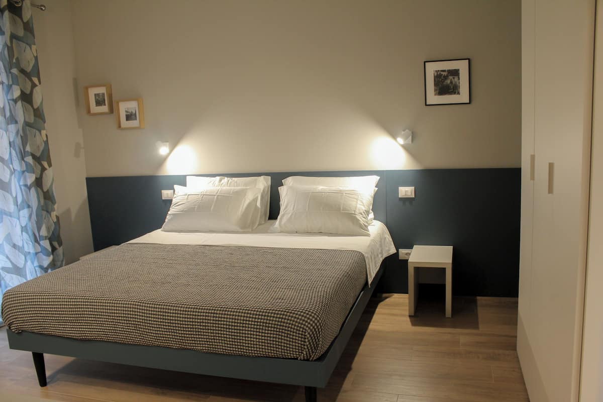Une chambre à coucher avec un lit, des tables de chevet et une commode.