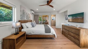 Une chambre à coucher moderne avec un lit en bois, une table de chevet, une commode et un ventilateur de plafond.
