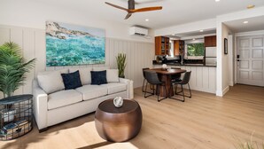 Un salon moderne avec un canapé, une table basse et un coin repas.