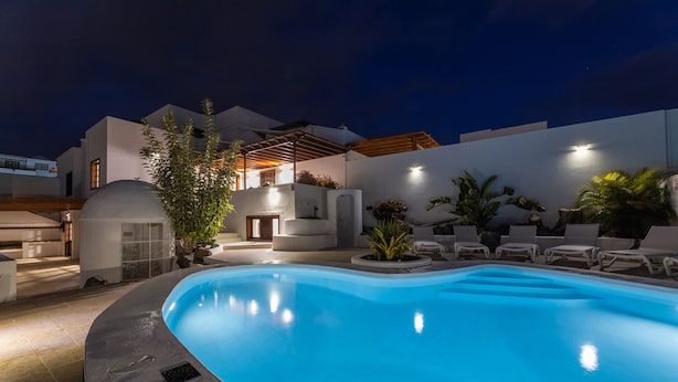 A swimming pool with lounge chairs and a covered patio area. - Villa Careva Suites 2 - VipVipVillas (Costa Teguise)