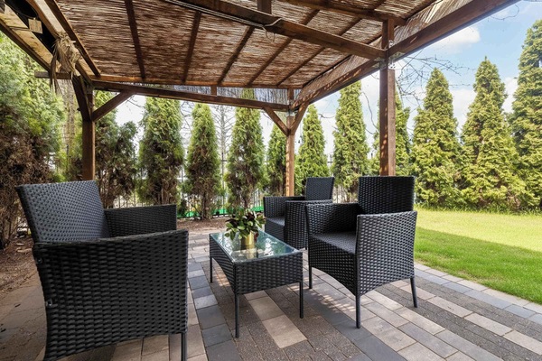 Outdoor seating area under pergola, perfect for relaxing moments.