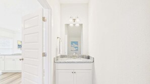 A bathroom with a white vanity, a mirror, and a towel rack. - Palmeras Place 170-Townhouse-Sleeps 10 (Panama City Beach)
