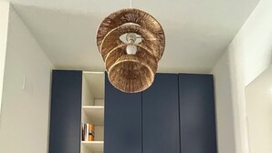 Ett sovrum med en våningssäng, en takfläkt och inbyggda hyllor ovanför sängen.