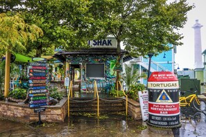 Un edificio colorido y ecléctico con un letrero que dice “SHAK” y una señalización que enumera varias atracciones locales.