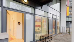 Un edifici modern amb grans finestres, una banca a l'exterior i una porta que condueix a un espai interior.