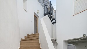 A staircase leading to an upper floor, a door, and a small window. - Belvedere Apartment with Views of Vejer’s Historic Old Town (Vejer de la Frontera)