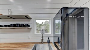 Una cocina moderna con un lavamanos de acero inoxidable, encimera de madera y un refrigerador Classic.