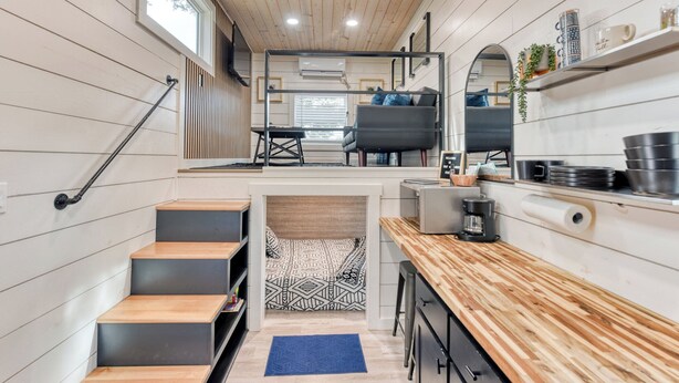 Een functionele keuken met een houten aanrecht, een koffieapparaat, en een gezellig zithoekje met een bank en een tafeltje.
