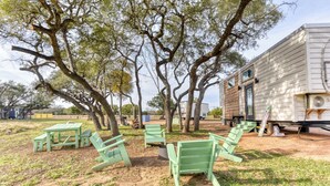 Uma casa móvel com um pequeno espaço de varanda com mobiliário de jardim verde.
