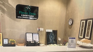 Een hotel receptiebalie met een bord waarop 'Flavor Zone Courtyard Hotel | Banquet | Restaurant' staat.