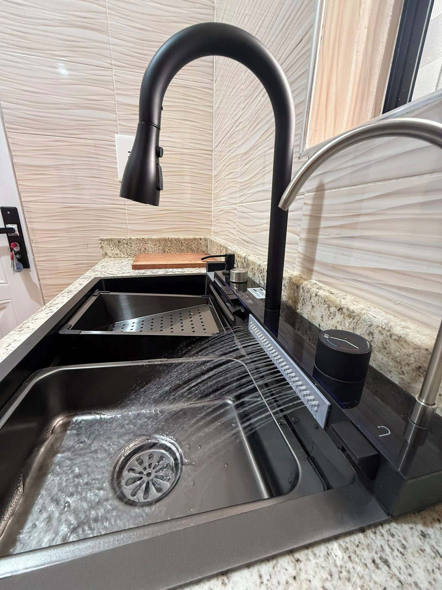 A modern kitchen with a stainless steel sink, a black faucet, and a coffee machine.