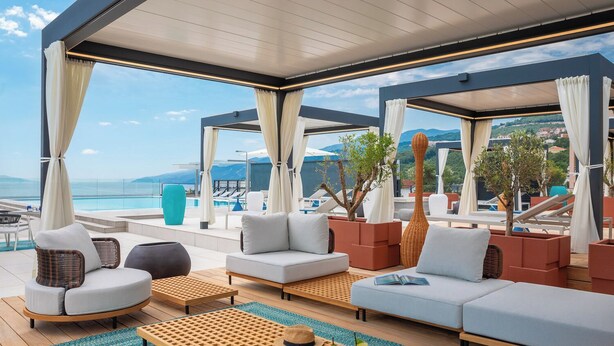 A modern outdoor lounge area with seating and a view of the sea. - Aminess Younique Vollo Hotel Residences (Opatija)