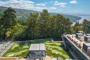 Um campo de golfe com área de deck, mobiliário de exterior e vista para a paisagem circundante.