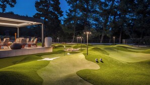 A well-lit outdoor area with a seating arrangement and a putting green. - Aminess Younique Vollo Hotel Residences (Opatija)