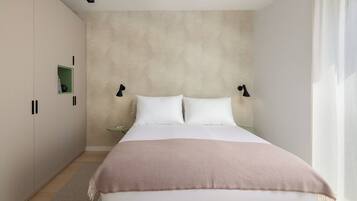 A bedroom with a bed, bedside tables, and a wardrobe.