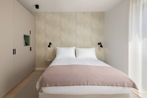 Un dormitorio con cama, mesitas de noche y armario.