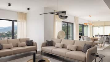 Un salon moderne comprenant deux canapés, une table basse et un coin repas avec une table et des chaises.
