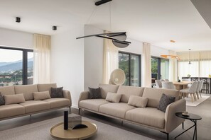 Un salon moderne comprenant deux canapés, une table basse et un coin repas avec une table et des chaises.