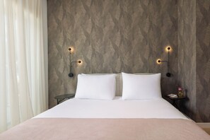 A hotel room with a bed, two bedside tables, and wall-mounted lighting. - Aminess Younique Vollo Hotel Residences (Opatija)