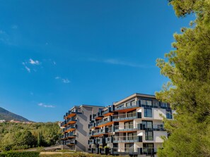 A multi-story residential building with balconies, surrounded by greenery and a clear sky. - Aminess Younique Vollo Hotel Residences (Opatija)