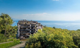 Un edificio moderno de varios pisos con balcones que dan a la costa.