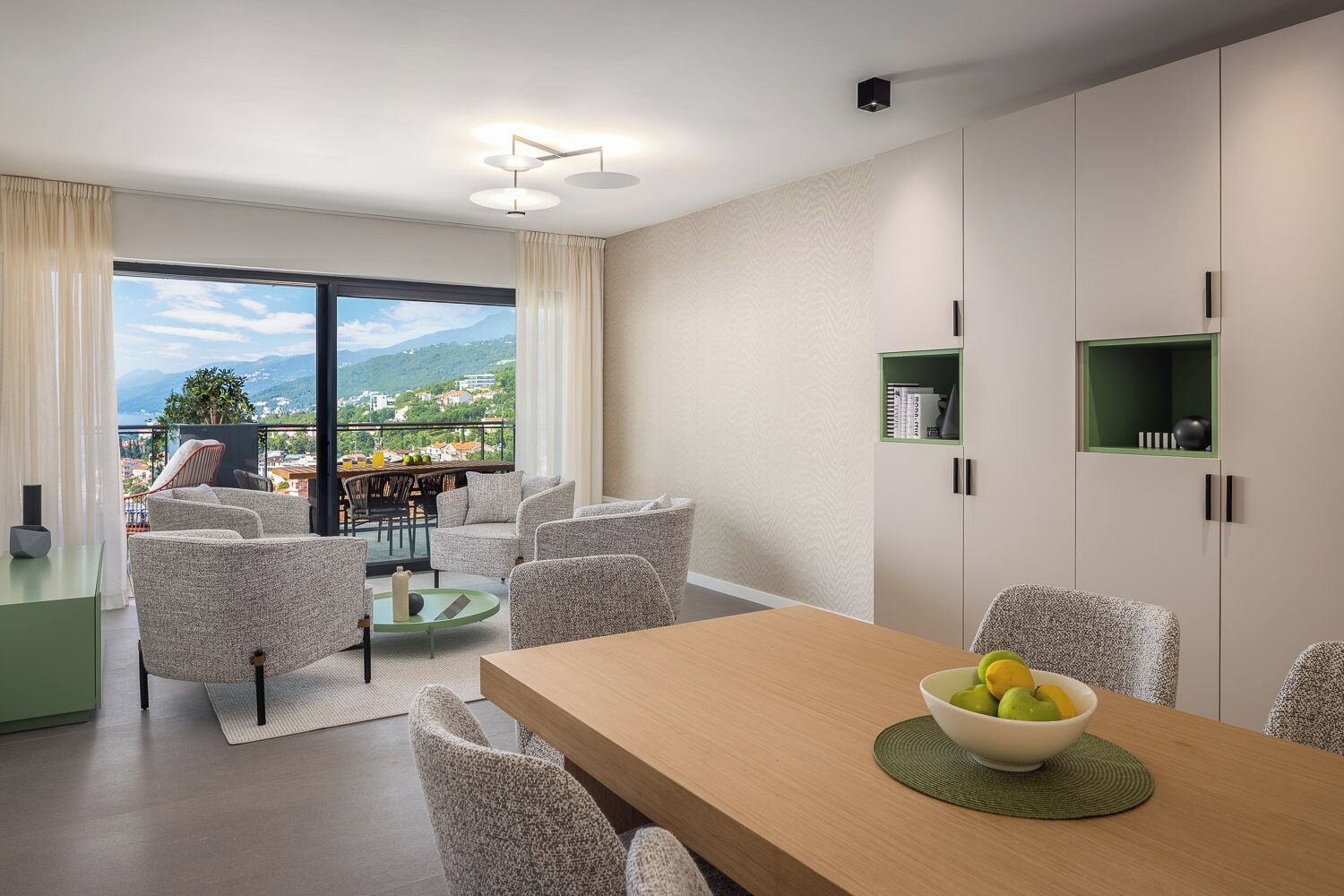Un interno moderno con zona pranzo, divani e vista sull'esterno.