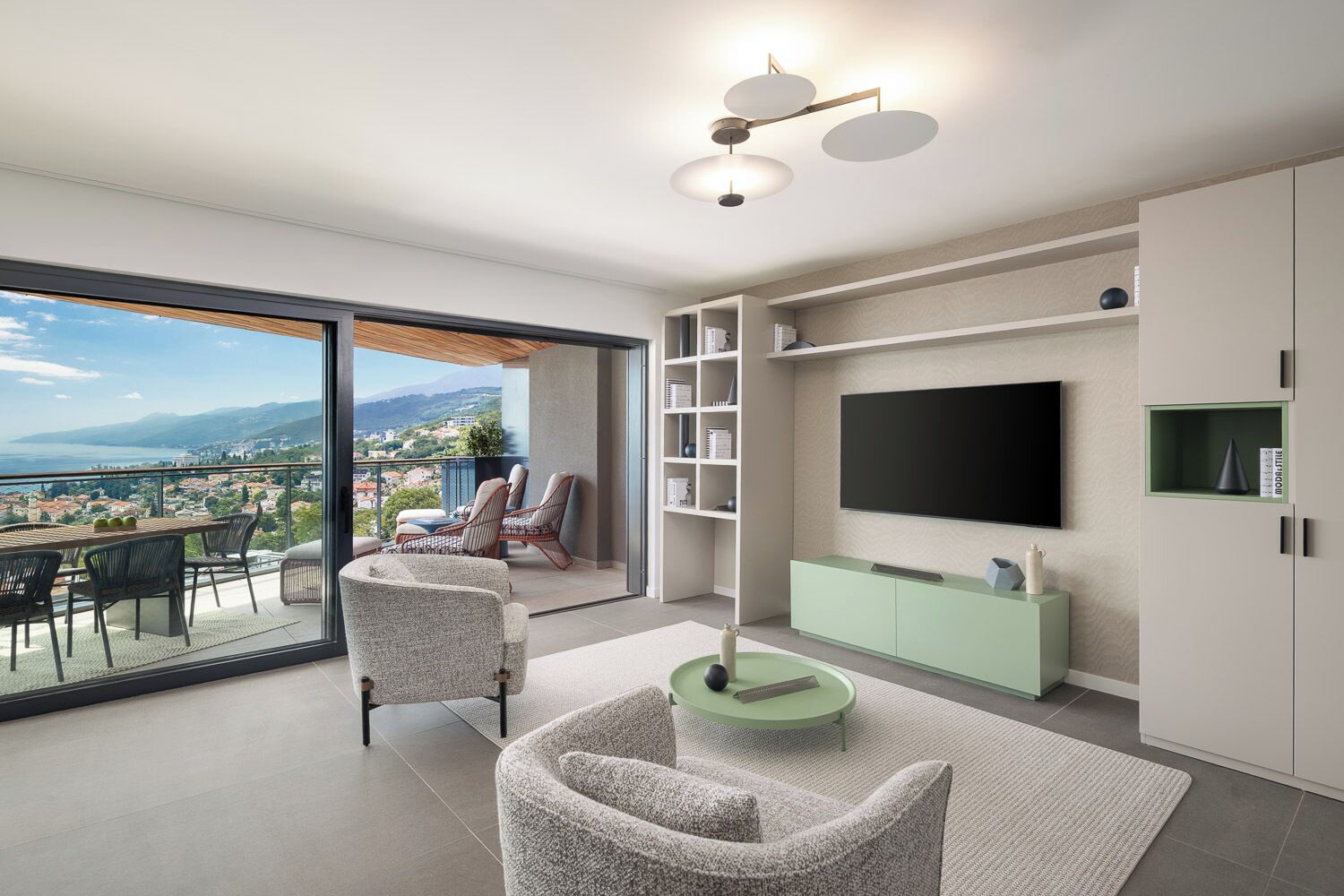 A modern living room with a large TV, seating area, and a balcony with a view.