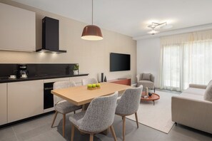 Una cocina moderna con comedor, televisor de pantalla plana y sofá.