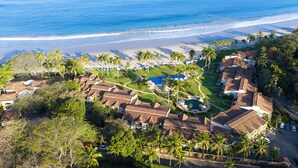 Ein Resort mit mehreren Villen, einem Pool und Blick auf den Strand.