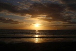 Ein Sonnenuntergang über dem Meer mit klarem Himmel.
