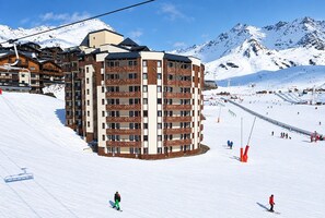 A multi-story hotel with a ski slope in the background. - Val Thorens - Ski In/Out - 4 Beds Flat (C-E19) (Les Belleville)