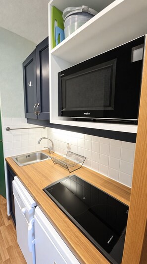 A modern kitchen with a built-in microwave, a dishwasher, and a wooden countertop. - Val Thorens - Ski In/Out - 4 Beds Flat (C-E19) (Les Belleville)
