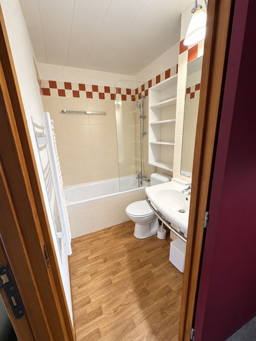 Une petite salle de bain comprenant une douche, des toilettes et un lavabo.