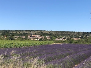 A rural landscape with a church, fields of lavender, and scattered houses. - Guest Room 'Gorges de l’Ardèche' with Shared Pool, Wi-Fi, and Air Conditioning (Saint-Remèze)
