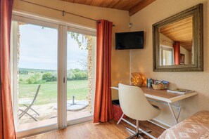 A room with a desk, chair, television, and a sliding glass door leading to an outdoor area. - Guest Room 'Gorges de l’Ardèche' with Shared Pool, Wi-Fi, and Air Conditioning (Saint-Remèze)