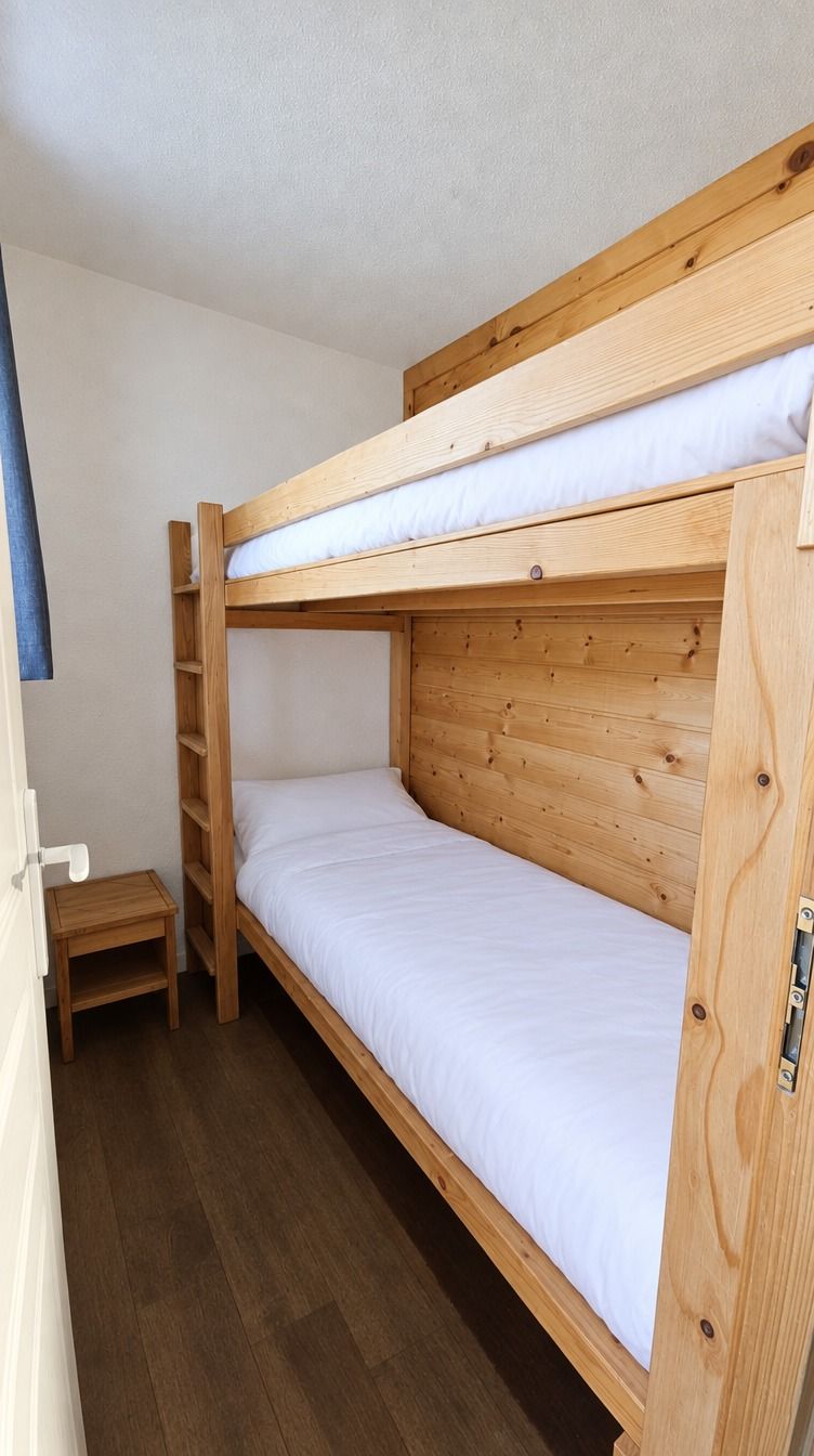A bunk bed with a wooden frame and white bedding.