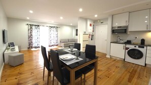 Um apartamento moderno com sala de jantar, cozinha e sala de estar.