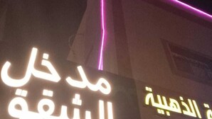 Ein Hotelschild mit arabischer Schrift und Neonlichtern.