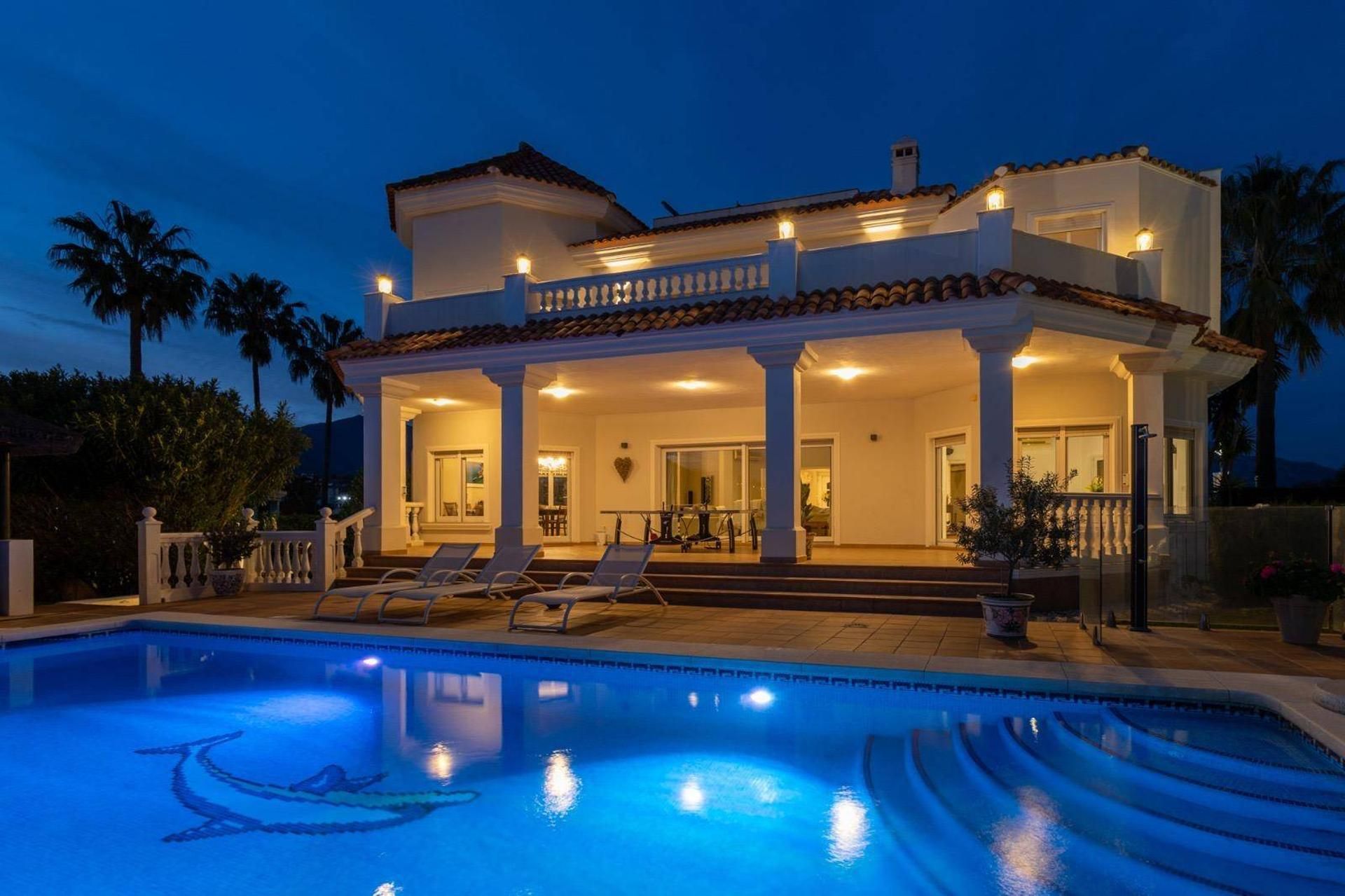 Una casa de dues plantes amb piscina al davant.