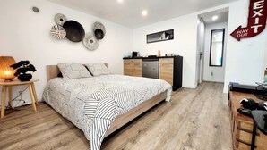 A bedroom with a bed, bedside table, lamp, and wall decorations. - Premium Suite near CDG Airport and Parc Astérix (Villeron)
