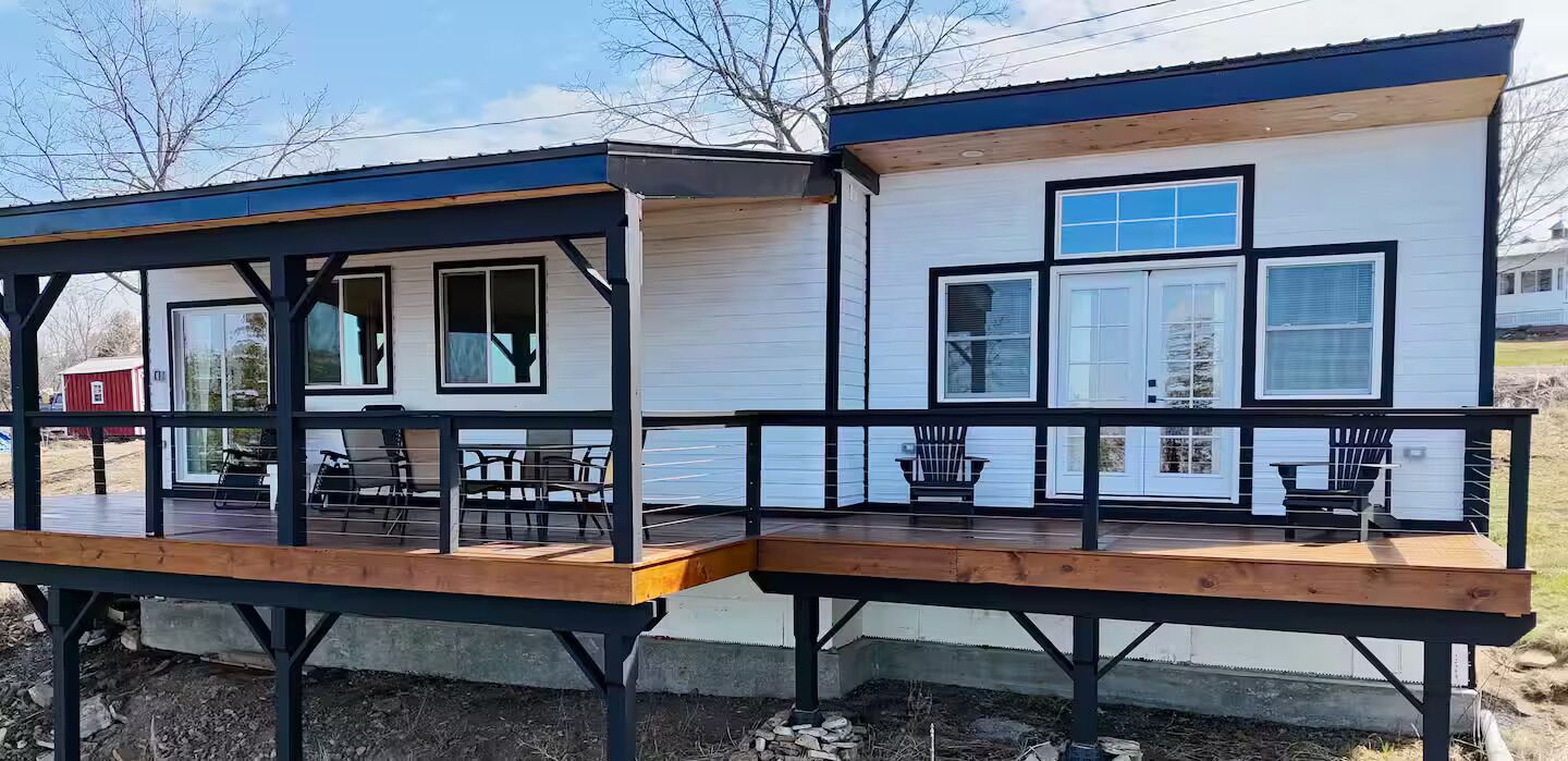 A two-story house with a covered porch and a deck.