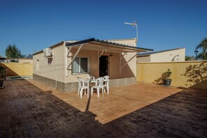 Uma casa pequena com um pátio, área de estar coberta e antena parabólica.